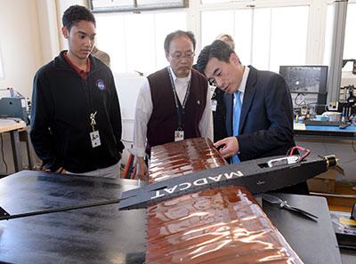Photograph of researchers inspecting an unmanned aircraft with morphing wings
