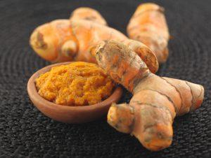 CURCUMA bienfaits millénaires Turmeric with turmeric paste on a brown pottery