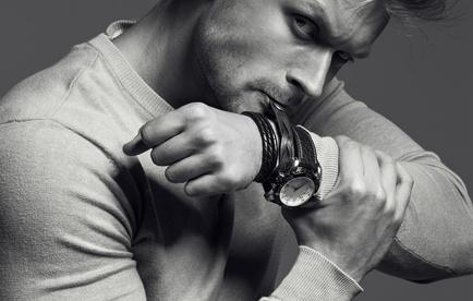 Advertising wrist watch concept. Beautiful (handsome) muscular male model with perfect body in grey jumper. He bites and unfastens th_110095661_XS