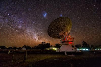 Photograph showing the Large (centre left) and Small (centre right) Magellanic Clouds in the sky above the Australia Telescope Compact Array
