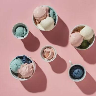 Six tasses de glace sont posées sur une table rose.