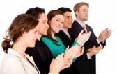 group of business people in an office applauding and smiling at success - focus is on the girl looking at the camera - isolated over white stock photo