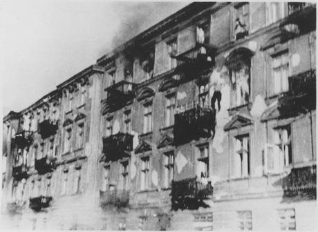 Photo d'une façade d'immeuble de 4 étages. Un homme est e train de tomber, dans le vide, entre le 4ème et le 3ème étage.