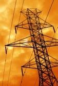The silhouette of a power line tower against an ominous orange sky. stock photo