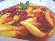 Soupe de mangue aux framboises et feuilles de menthe.