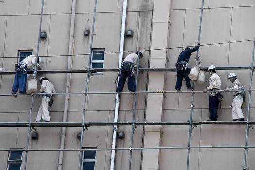 Des ouvriers sur une façade d'un building de Tokyo