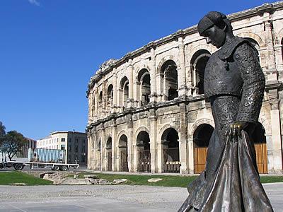 Les arènes de la ville de Nîmes avec une statue de toréador