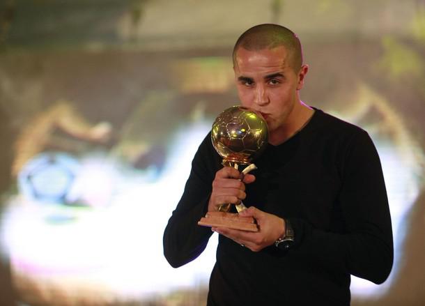 Glasgow Rangers player Madjid Bougherra kisses the Golden Ball trophy for Algerian Player of the Year 2009 during a celebration organized by Algerian sports newspaper Le Buteur in Algiers December 21, 2009.