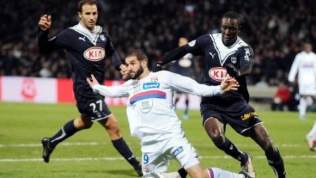 Le joueur de Lyon Lisandro Lopez (c) à la lutte avec les joueurs de Bordeaux Marc Planus (g) et
