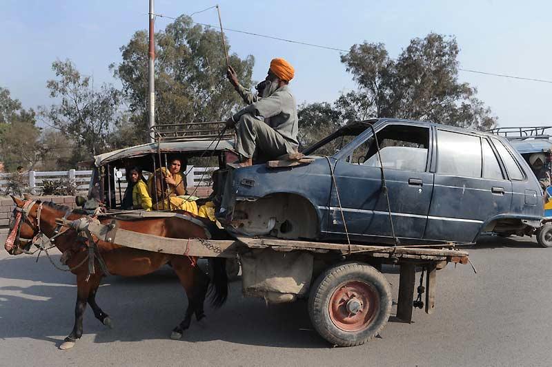 Étrange moyen de locomotion : une carcasse de voiture sur un pousse-pousse, tracté par un cheval. La scène se passe à Amritsar, ville située au nord-ouest de l'État du Panjâb indien, mardi 16 février. 
