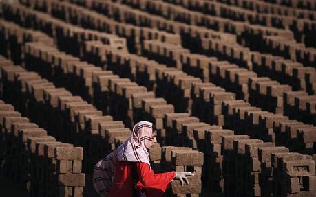 Une femme pakistanaise travaille dans une usine de fabrication de briques dans la banlieue d'Islamabad, au Pakistan, lundi 8 mars, jour de la célébration de la journée internationale des femmes. 