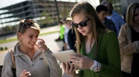 Deux jeunes filles testent l'iPad sur le campus d'une université au Texas