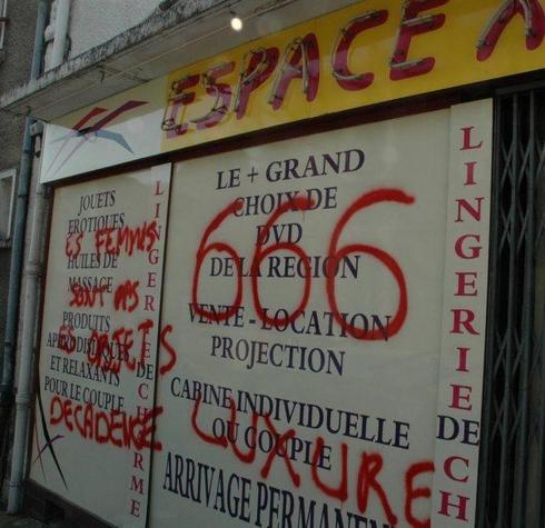 Sur les deux sex-shops, les mêmes inscriptions peintes en rouge : « Les femmes ne sont pas des objets », « luxure » et « décadence ». - 