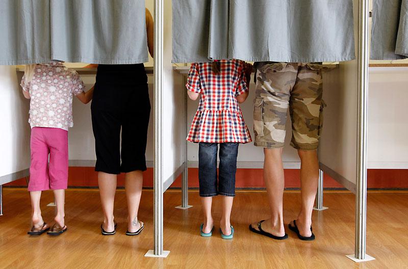 Dimanche 13 juin, des citoyens belges accompagnés de leurs enfants votent dans un bureau, à Bracle, commune située en région flamande. 