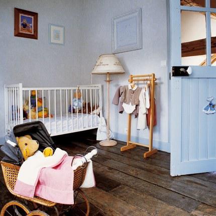 Chambre de petite fille, avec un lit à barreaux et du parquet en bois brut au sol