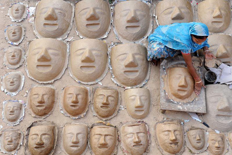 Lundi 3 octobre, à Amritsar, ville indienne située au nord-ouest de l'État du Panjâb, cette femme confectionne des masques, à l’occasion des prochaines festivités de Dussehra qui débuteront le 17 octobre prochain. 