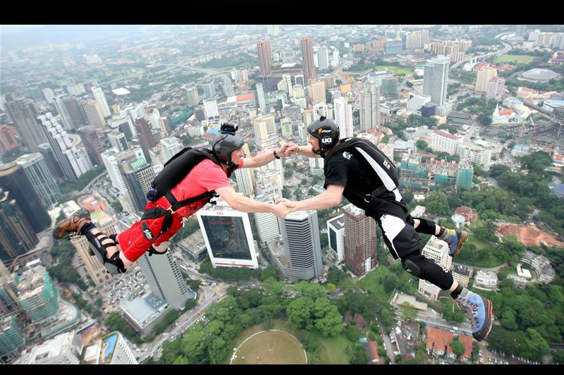 Jeudi 7 octobre, ces hommes participent au concours annuel de saut en parachute depuis le sommet des tours jumelles Petronas de Kuala Lumpur, en Malaisie, qui culminent à 452 mètres. 