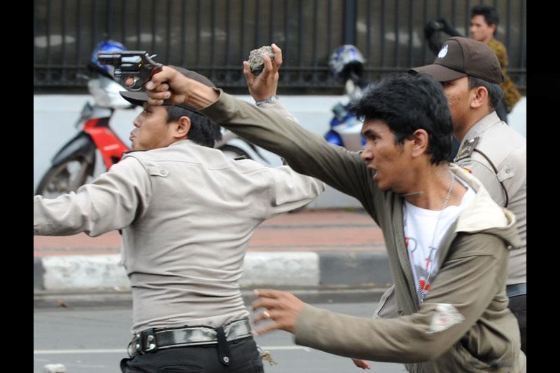 Mercredi 20 octobre, devant le palais présidentiel, à Jakarta, des policiers affrontent des manifestants avec des armes et des pierres. Des milliers d'Indonésiens ont défilé pour protester contre la politique du président Susilo Bambang Yudhoyono. 