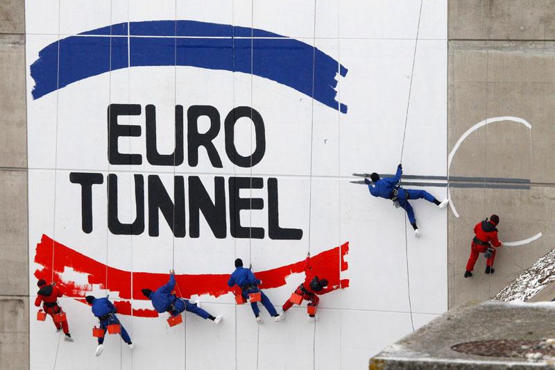 Mardi 1er décembre, pour célébrer le 20ème anniversaire de la première galerie creusée sous la mer entre la France et l'Angleterre, des ouvriers peignent un logo géant à l’entrée du tunnel, à Coquelles. La construction du tunnel sous la manche, qui a été inauguré en 1994, aura duré six ans.