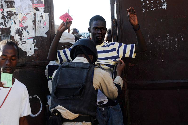 Dimanche 28 novembre, devant l’entrée d’un des bureaux de vote de Port-au-Prince, en Haïti, les fouilles sont de rigueur. Les élections se sont achevées dans la confusion : douze des dix-huit candidats au scrutin présidentiel ont réclamé son annulation en faisant état de fraudes massives.