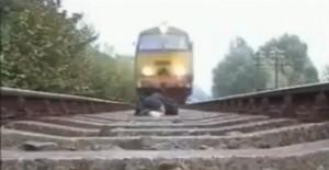 Couché sur les rails, il filme le passage du train sur lui