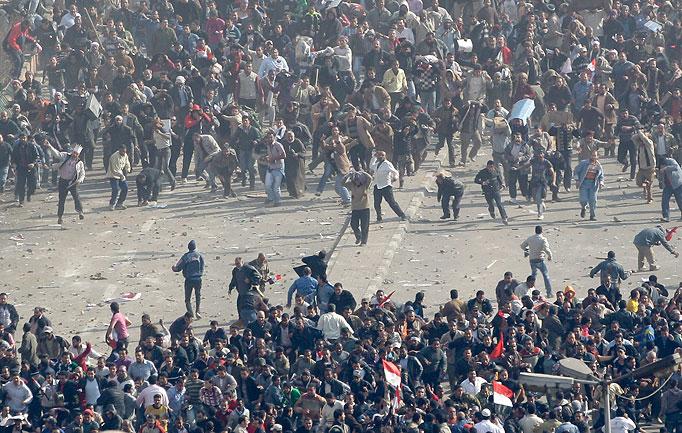 Fighting ... pro Mubarak and anti-Government protesters clash today