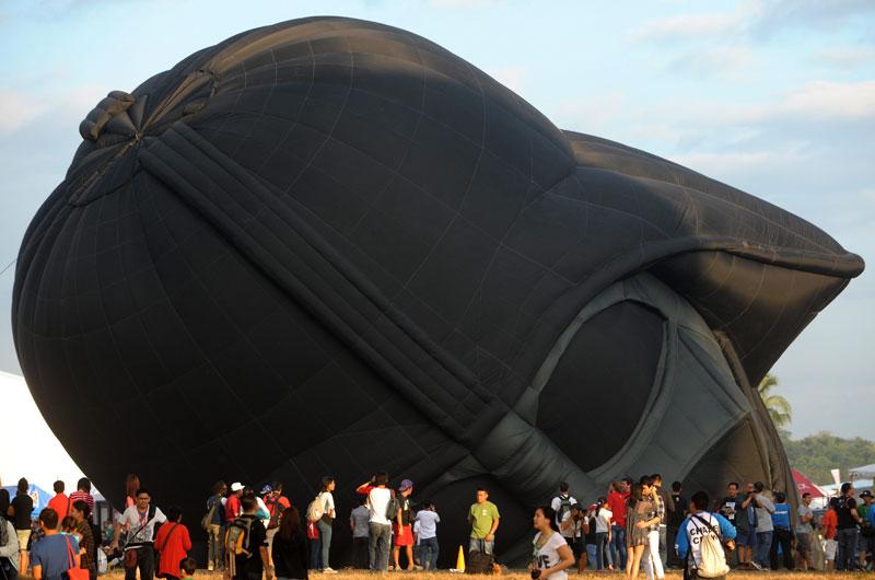 Des milliers de spectateurs ont assisté au 16ème festival Hot Air Balloon, à Pampanga, aux Philippines, jeudi 10 février. Ici le gonflage d’une montgolfière représentant un casque géant de Dark Vador.