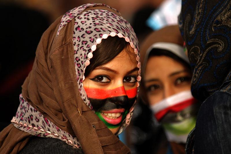 <b></div>LES VOILES DE LA LIBERTÉ.</b> Sur leurs visages, l’ancien drapeau de la monarchie libyenne, rouge-noir-vert, les couleurs de l’indépendance de la Libye en 1951 jusqu’à la révolution qui a porté au pouvoir le colonel Kadhafi en 1969. Si les jeunes filles de Benghazi, où les opposants au régime ont fait sécession, célèbrent leur victoire, le pays s’enfonce chaque jour davantage dans la confusion et la violence. En milieu de semaine, les forces loyales à Mouammar Kadhafi sont ainsi entrées à Marsa el-Brega, à 200 kilomètres au sud de Benghazi, une ville jusqu’alors contrôlée par les insurgés, tandis qu’aux frontières du pays, des milliers de Libyens tentaient de fuir le chaos. 