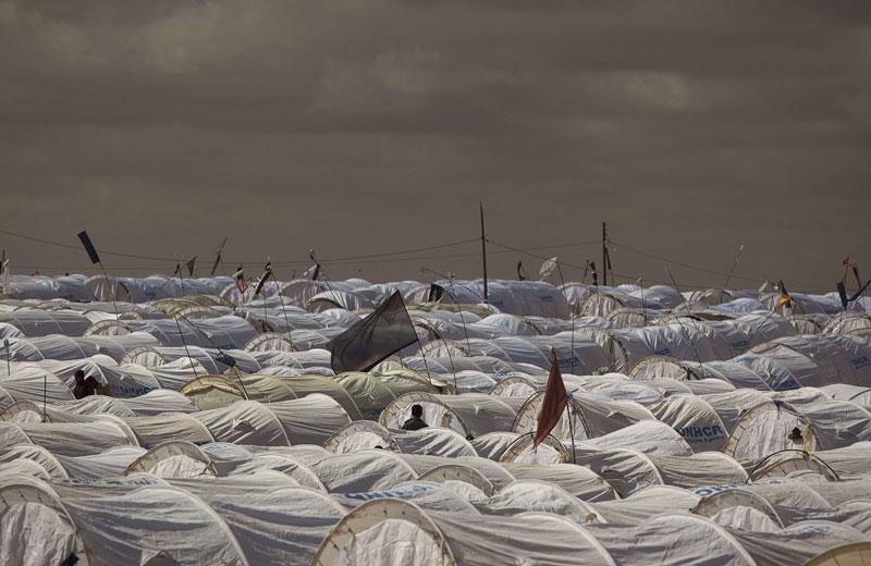 <b></div>DANS L’ATTENTE</b>. À perte de vue, des tentes légères frappées du logo du Haut Commissariat pour les réfugiés des Nations Unies (UNHCR). Bienvenue à Ras Jdir, le principal camp de réfugiés situé en Tunisie, près de la frontière libyenne. Près de trois semaines après le début des émeutes et des combats à l’arme lourde, près de 215.000 migrants ont quitté la Libye, mais le mouvement a faibli à la fin de la semaine dernière, selon le HCR. «La situation évolue de façon très préoccupante en Libye et nous devons être prêts à un éventuel exode. Il est impossible de savoir exactement ce qui se passe de l’autre côté», explique, alarmé, Antonio Guterres, le chef du Haut Commissariat pour les réfugiés. 