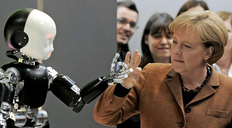 Lundi 19 avril, la chancelière allemande, Angela Merkel, touche de ses doigts la main d’un robot lors de l’ouverture de la foire industrielle d'Hanovre.