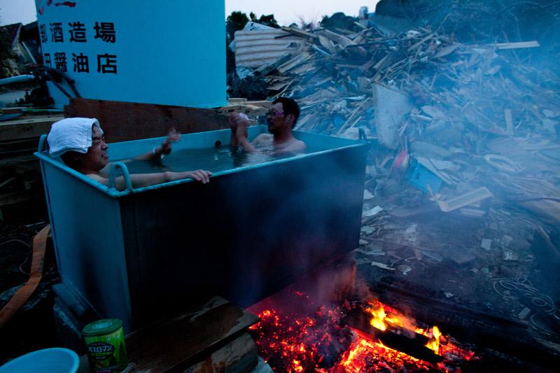 <b></div>Un bain chaud.</b> Au milieu des débris de la ville de Kesenumma, dans la préfecture de Miyagi, ces deux hommes réussissent à prendre un bain. Alors qu’il y a un peu plus d’un mois un tsunami rasait le Tohoku – la région nord-est du japon -, le pays continue de lutter afin de redresser une situation qui reste sur le fil.