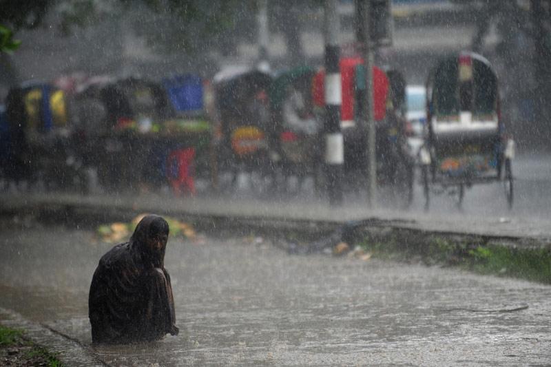 <b></div>Trempé.</b> Le 16 mai, un sans abri, assis au bord d’une route à Dhaka au Bangladesh, subit les violentes pluies de la mousson, souvent accompagnées d’orages soudains et d’une rare violence. Ce pays a un climat de mousson subtropicale caractérisé par de larges variations saisonnières, les fortes précipitations sont donc fréquentes.