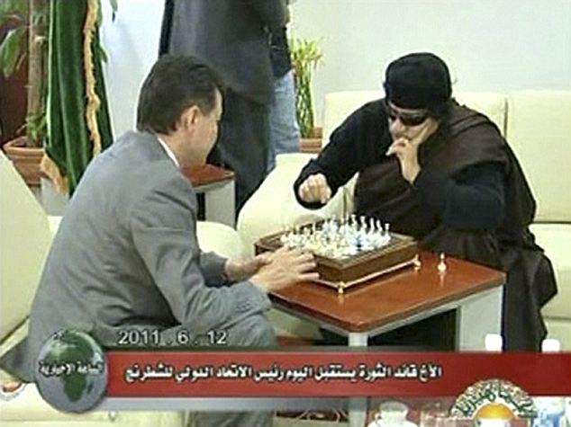 Muammar Gaddafi plays chess with Kirsan Ilyumzhinov, the president of the international chess federation, on state television yesterday