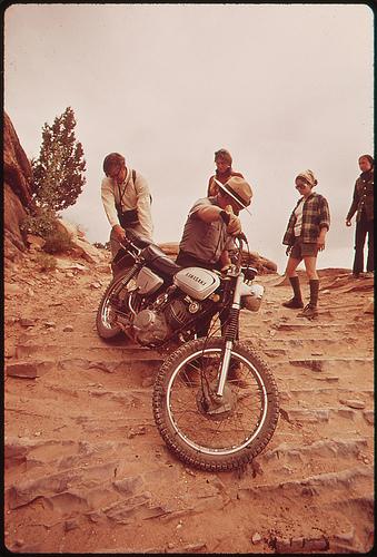 Park Ranger Lends a Hand to Motorcycle Rider Who Can't Manage His Bike on the Steep Road Elephant Hill, Needles Section, 05/1972