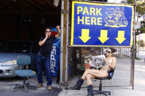 Erica Simone, lisant le journal devant un parking