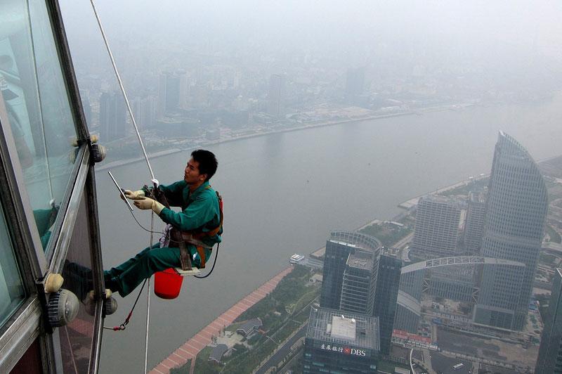 <b></div>À main d’hommes</b>. Une chose est certaine : il ne faut pas avoir le vertige. Attaché à un simple harnais de sécurité et suspendu à plusieurs centaines de mètres au dessus du sol, cet ouvrier nettoie les vitres de La Perle de l’Orient, cette tour de télévision de Shanghai, en chine. Comme lui, plusieurs équipes de laveurs virevoltent ainsi à ciel ouvert, les sociétés de nettoyage continuant de préférer ces alpinistes improvisés, aux machines, le prix de la main d’œuvre étant imbattable. 