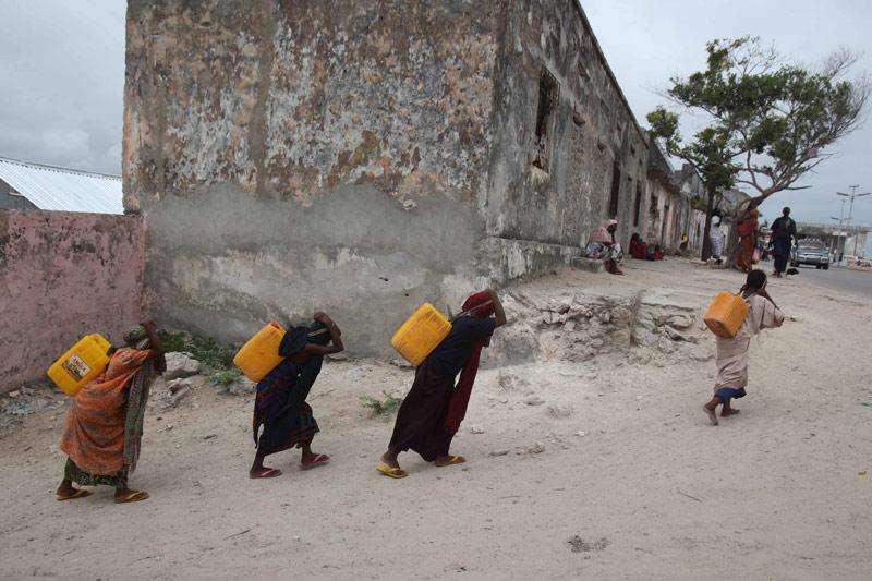 Alerte à l’alerte. A Mogadiscio, les victimes de la sécheresse se battent pour leur survie. Ici, dans un des camps de fortune qui fleurissent autour de la capitale somalienne, des femmes, réfugiées de la faim, portent des jerrycans d’eau pour réhydrater leurs enfants. Les Nations unies viennent d’affirmer que la famine s'était encore étendue. Une sixième région est désormais frappée, celle de Bay, et 750.000 personnes sont menacées de mort dans ce pays, le plus touché de la Corne de l'Afrique. Le précédent bilan de l'Onu, en juillet, faisait état de 450.000 personnes en danger de mort. 