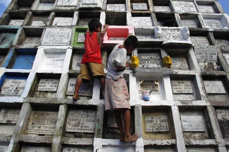 <b></div>Grand nettoyage.</b> Ces enfants de Manille ont fait du nettoyage des tombes, une spécialité. Pour la Toussaint, ils ont ainsi repeint et dépoussiéré des dizaines de sépultures. Dans les cimetières de la capitale des Philippines, un pays surpeuplé où 80% de la population est catholique, le plus difficile est de trouver de la place pour les défunts. Alors les autorités ont imaginé ces étranges immeubles funéraires qui ne cessent chaque année de prendre de la hauteur. 