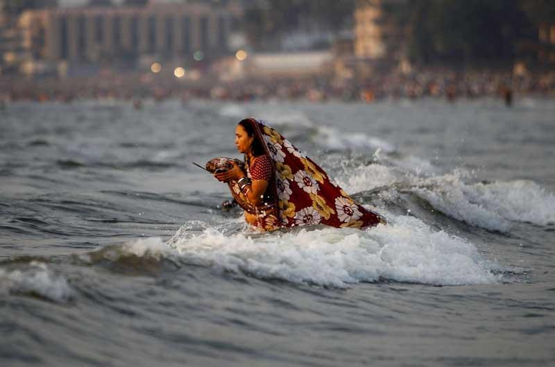 <b></div>Offrande au soleil.</b> Les muscles tétanisés pour mieux résister aux flots de la mer d’Oman, au pied de la ville indienne de Mumbai (Bombay), cette femme va rester en prière de longues heures, psalmodiant des poèmes rituels en l’honneur de l’astre solaire, à l’occasion d’une des plus importantes fêtes religieuses du calendrier hindou : le festival du Chhath. Chaque année, une foule immense se précipite au bord de la mer ou sur les rives du Gange pour adorer le Soleil et tenter d’attirer sa bénédiction. Un rite dont les racines plongent dans les plus anciennes croyances humaines. Dans la cosmogonie de l’hindouisme, le dieu Soleil doit être remercié pour sa lumière et sa chaleur, garante de la vie sur Terre. 