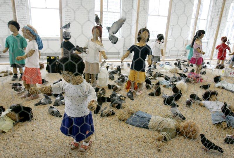 <b></div><i>Flying rats</i>, Kader Attia</b><br> Cette œuvre de l’artiste français, présentée en 2005 à la Biennale de Lyon, a choqué quelques visiteurs. <i>Flying rats</i> représentait 45 mannequins d’enfants, dont les corps étaient constitués de mousse et de graines et qui se faisaient dévorer dans une immense cage par des dizaines de pigeons vivants.