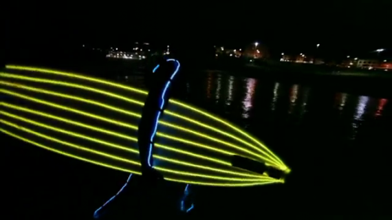Surf nocturne avec combi et board à néons sur Bondi beach !