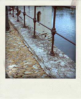 une photo en noir et blanc.Une rue ( les pavés du pont d'...