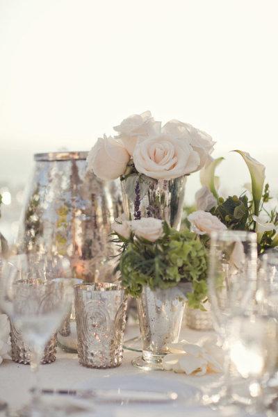 Succession de petits vases et de photophores en centre de table de mariage