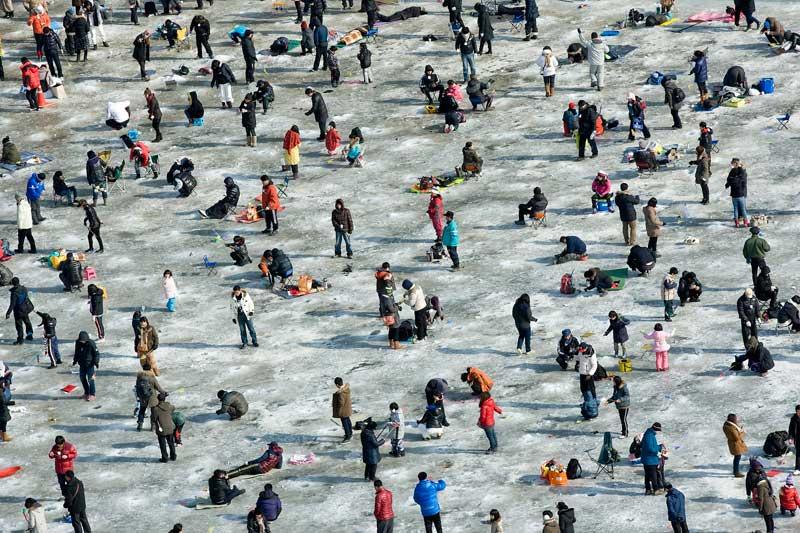 <b></div>Où est Charlie ?</b> Comme chaque année à la même période, dans le froid piquant de l'hiver coréen, le lac du canton de Hwacheon, dans la région du Gangwon, s’est recouvert d'une épaisse couche de glace et accueille l'un des festivals les plus populaires de l'hiver, sinon de l'année entière : celui de la truite des montagnes qui vit dans l'eau argentée du lac, la Sancheoneo. Depuis le 7 janvier, et pour trois semaines, la région s'est animée autour de cet événement qui draine des dizaines de milliers de visiteurs. Pêche à mains nues, ici en image, dégustations en tous genres, sculptures de glace, concours, animations... de la joie pour les grands et les petits ! 