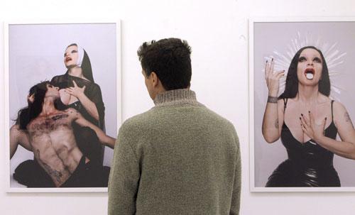 Un visiteur devant deux clichés de l'exposition Obscenity 