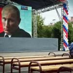 Ecran geant representant Poutine devant une assemblée presque vide