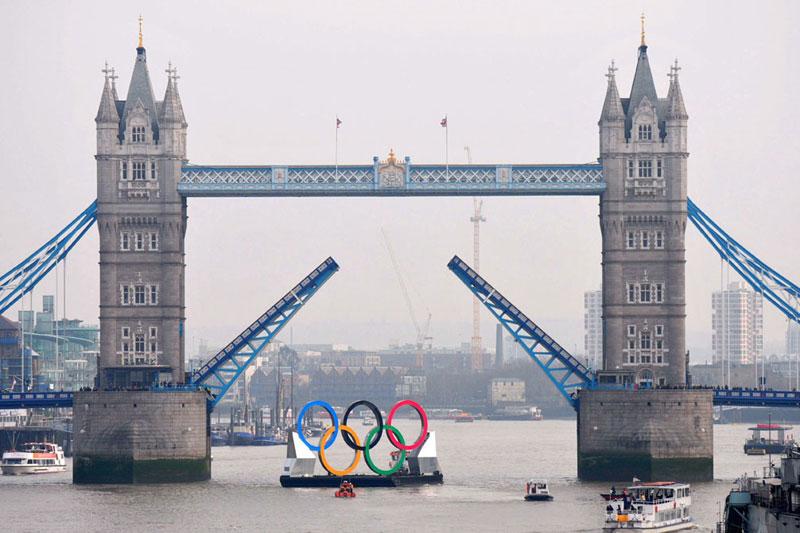 J.O 2012. J-150 avant le lancement des Jeux olympiques de Londres 2012. Dans le cadre de la célébration de cet évènement, une barge a été mise à l’eau avec à son bord les 5 anneaux olympiques. L’embarcation, longue de 25 mètres, parcourt la Tamise et va passe même sous le célèbre «Tower Bridge». Le maire de Londres, Boris Johnson, a participé à la cérémonie d’inauguration et en a profité pour annoncer tout une série d’évènements culturels jusqu’à l’ouverture des jeux.