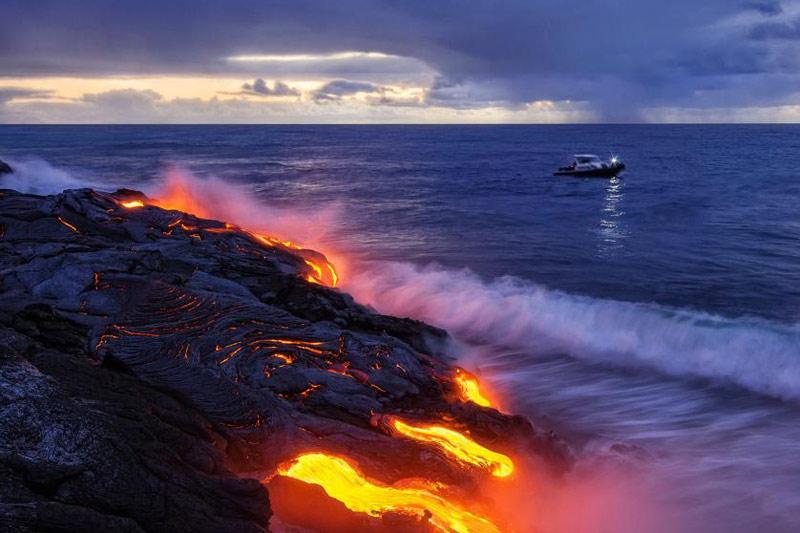 <b></div>Chaud froid.</b> C'est une scène hors du temps. Sans la silhouette doucement illuminée du petit navire qui croise à quelques mètres du bord, on pourrait se croire revenus aux temps géologiques. Comme il y a plus de 3 milliards d'années, le même combat se joue ici. Mais à beaucoup plus petite échelle, à l'image de cette coulée de lave du volcan Kilauea, à Hawaï, qui vient s'éteindre dans l'océan Pacifique. À chaque éruption, en effet, des milliards et des milliards de particules chimiques et minérales se déversent dans l'eau et apportent des nutriments essentiels à la vie de la flore et la faune marines. Mais aussi des poisons violents. Un véritable chaudron de sorcière... 