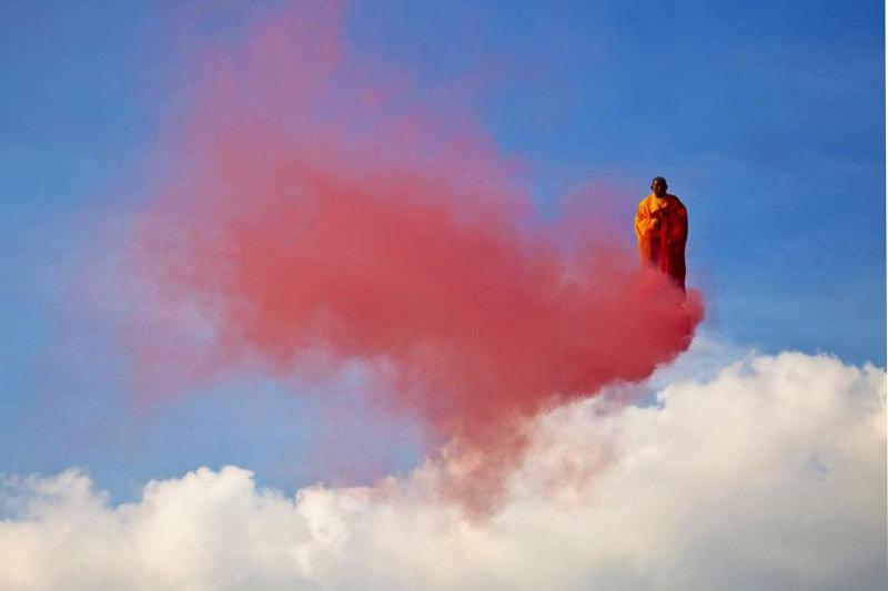 <b></div>Moine fumeux.</b> En prière dans un état de conscience hors du commun, ce moine bouddhiste en lévitation transcendantale a réussi l'incroyable exploit de chevaucher un nuage rouge au beau milieu du ciel. Rouge comme le feu et la passion. Un miracle en somme. Sauf que sous la robe safran de ce curieux paroissien se cache l'artiste chinois Li Wei, et derrière le nuage, la plate-forme d'une grue qui le maintient dans les airs attaché par un harnais, juste au-dessus de la Fontaine aux lions du parc de la Villette à Paris. Dommage non? Reste cette intrigante fumée écarlate? Là encore, le maître en illusions d'optiques et en installations aériennes a trouvé une solution idéale: Li Wei a tout simplement attaché des feux de Bengale à ses chaussures. Une jolie fumisterie.