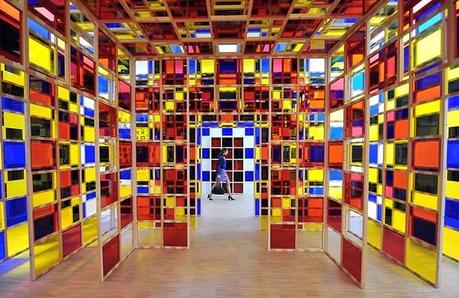 A woman walks past an installation by Fr Daniel Buren – Monumenta 2012 – Excentrique(s) Travail in Situ au Grand Palais + Eléments de biographie et quelques oeuvres